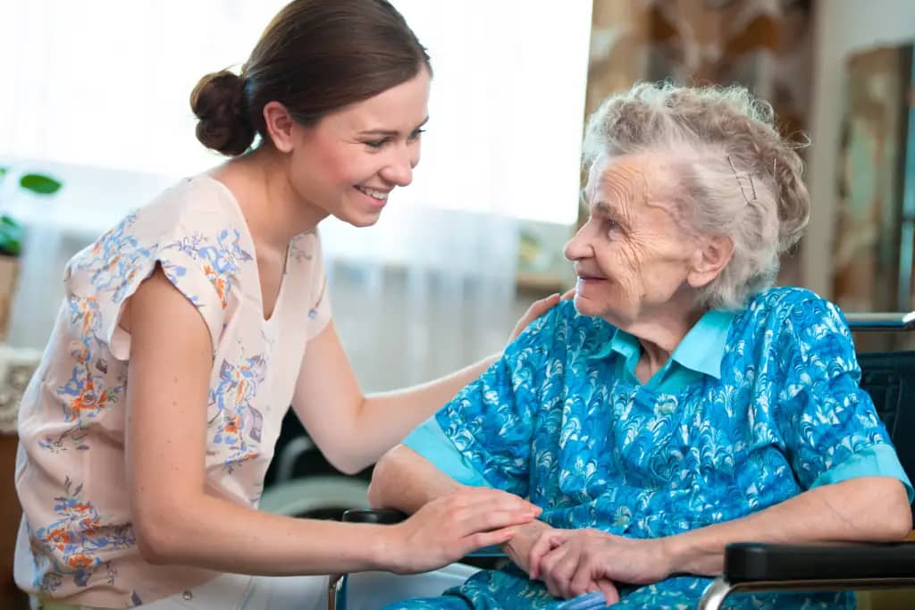 caregiver holding elder consumers hand .